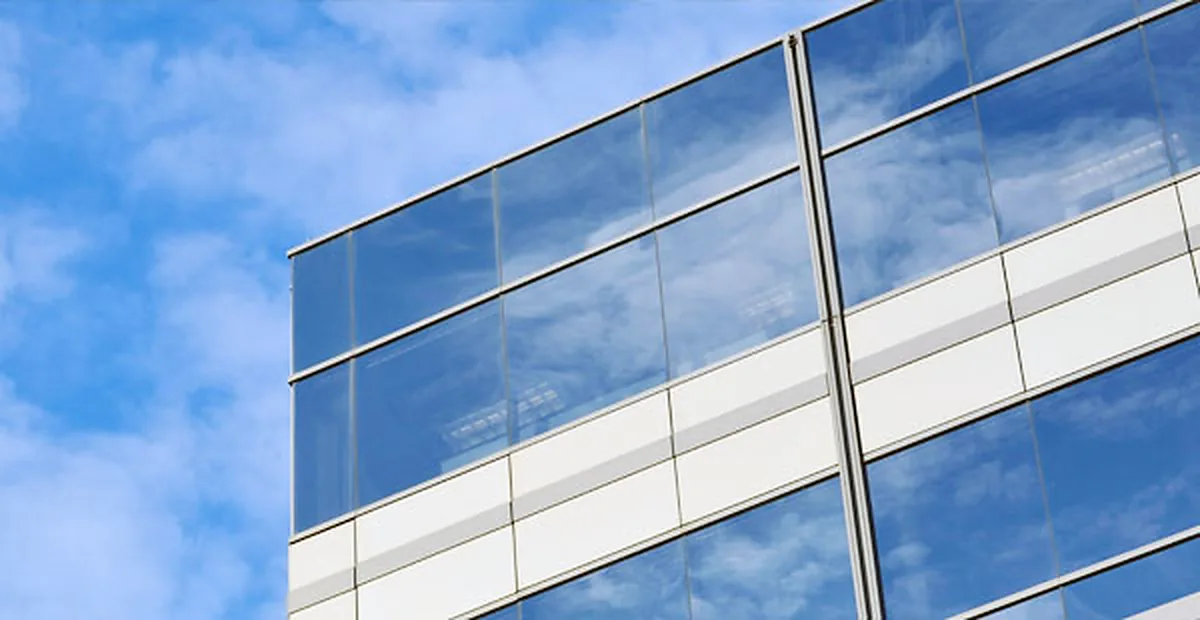 Glass building façade against a blue sky