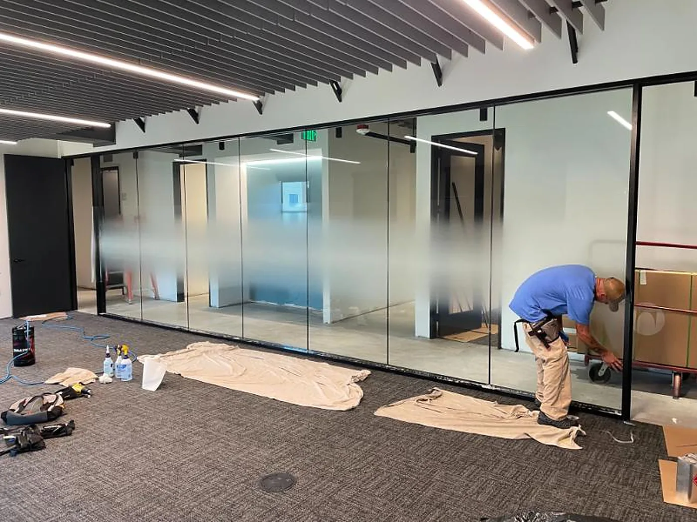 Installer applying frosted film to a glass office wall